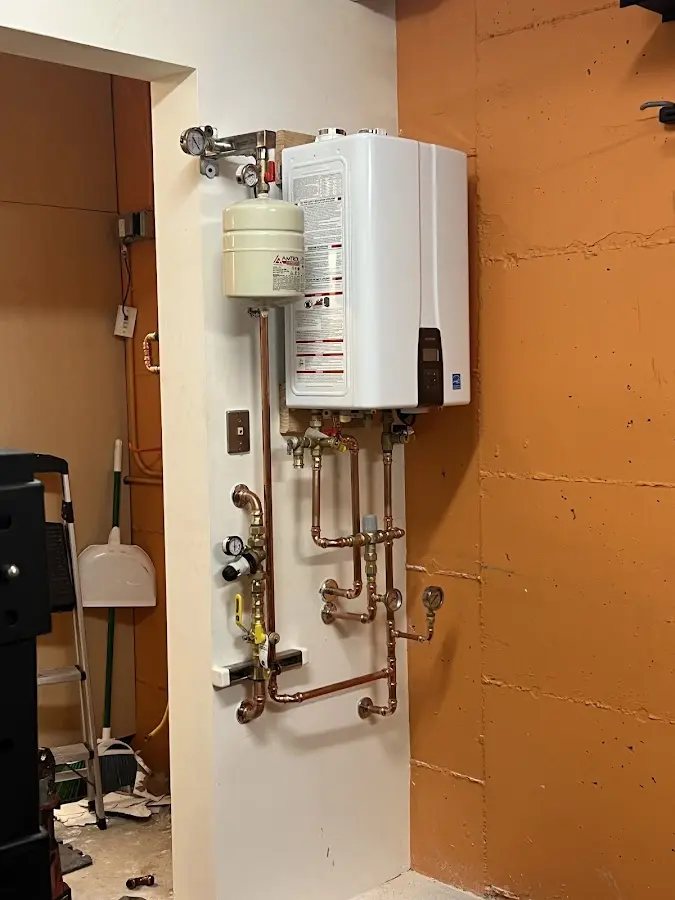 Plumbing technician inspecting water heater connections in West Pensacola